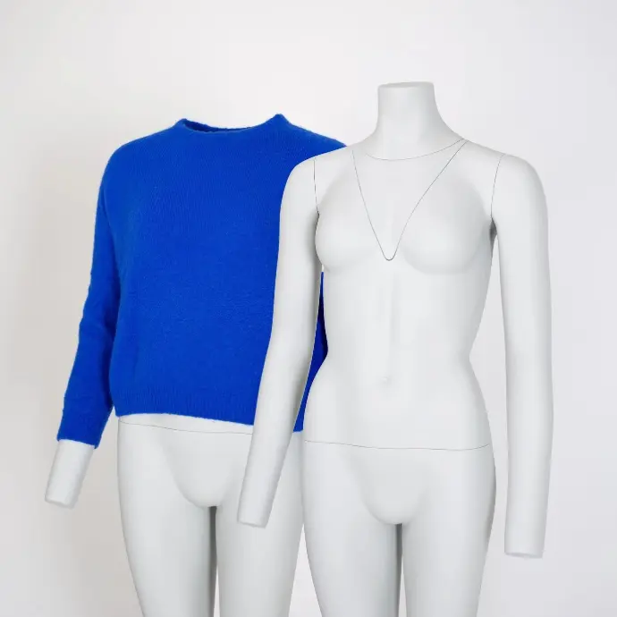 Blue knitted sweater on a ghost mannequin next to a bare white mannequin, set up for clothing photography